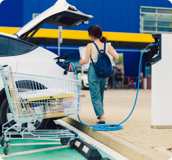 A woman plugging in an charger into her EV