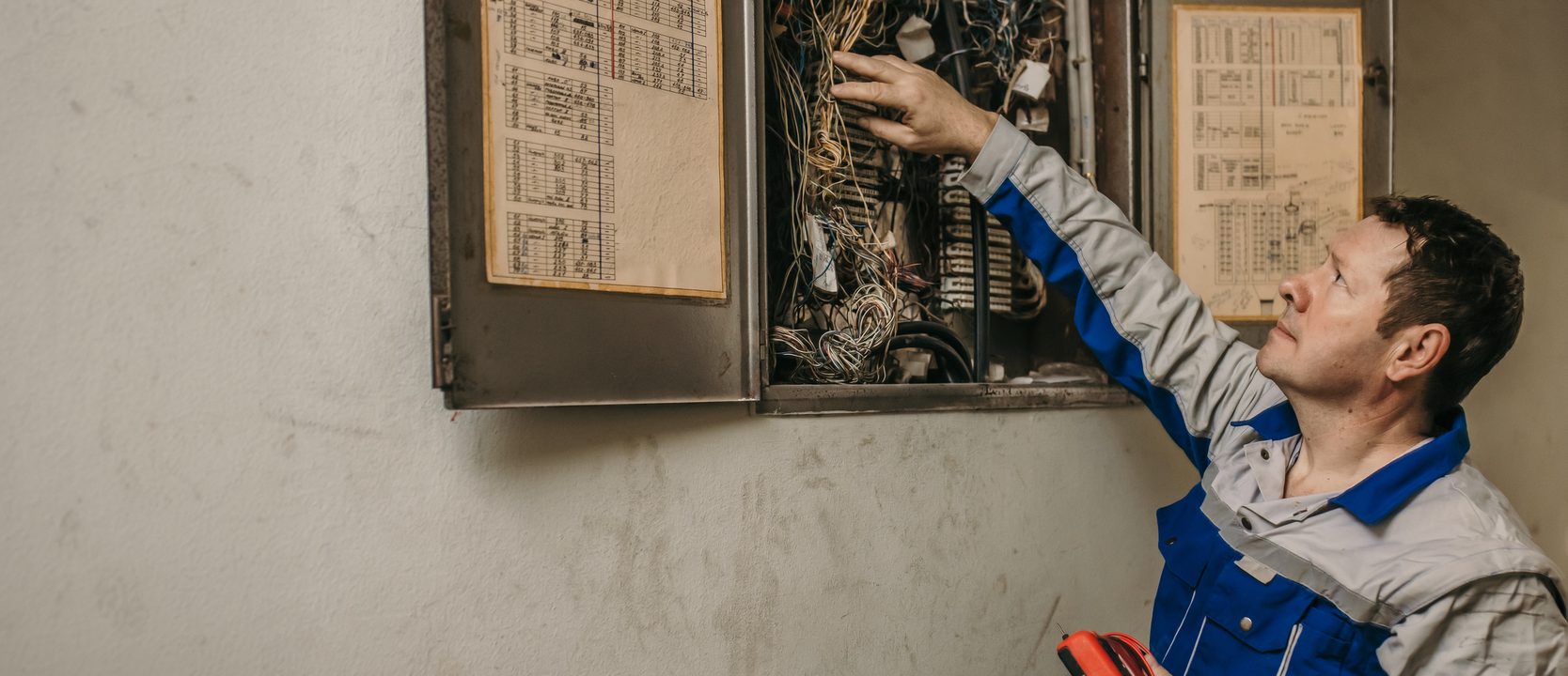 An electrician working on an electrical panel